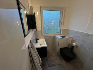 a bathroom with a toilet and a sink and a window at House Bahamas in Büdingen +112 photos