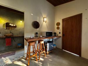 a kitchen with two bar stools and a counter at Pousada Ocazum Ilha do Amor in Alter do Chao