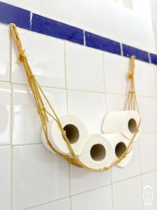 a rack of toilet paper hanging on a tiled wall at Eco Bay Surf House in Agadir +140 photos