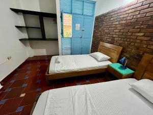a room with two beds and a blue door at Sana Mar Hostel & Eco-Café in Santa Marta