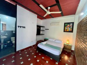 a bedroom with a bed and a ceiling fan at Sana Mar Hostel & Eco-Café in Santa Marta