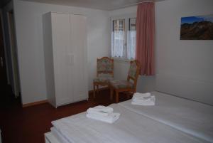 イゼルトヴァルトにあるFamily-Apartment Du Lacのベッド1台、椅子、窓が備わる客室です。