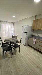 a kitchen with a table and chairs and a refrigerator at Sobrado Vila Industrial in Toledo +14 photos