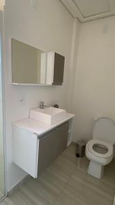 a bathroom with a white sink and a toilet at Sobrado Vila Industrial in Toledo
