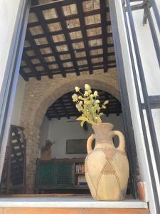 a vase sitting on a shelf with flowers in it at Arcos de la Loba by casitasconencantoes in Medina Sidonia