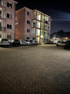 坎帕拉Green vee apartment的建筑物前停放汽车的停车场 更多2张照片