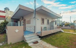 una piccola casa bianca con scale in un cortile di Crystal Cherry Apartment a Preveza