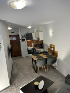 ein Wohnzimmer mit Tisch und Küche in der Unterkunft Elizi1winter apartments Pamporovo in Pamporowo