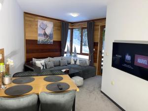 ein Wohnzimmer mit Tisch und Couch in der Unterkunft Elizi1winter apartments Pamporovo in Pamporowo