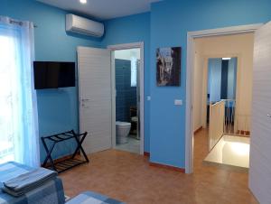 un soggiorno con parete blu e TV di Ibla nel Cuore a Ragusa