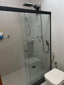 a glass shower in a bathroom with a toilet at Casa nova e aconchegante in Americana