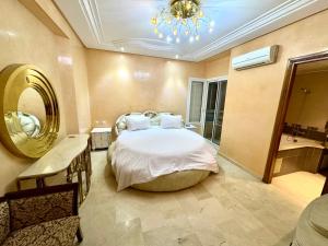 a bedroom with a large bed and a mirror at Luxueux appartement Assouan centre-ville in Fès +14 photos