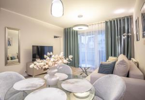 a living room with a couch and a table and chairs at Apartamenty na Wyspie - Stella Baltic - Parking in Świnoujście