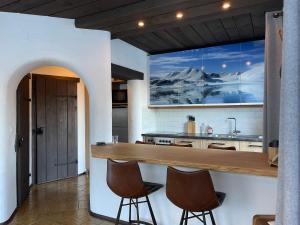 a kitchen with a counter and two stools at Apartment Ivy, Mountain view in Kaprun