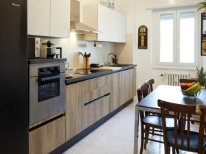 a kitchen with white cabinets and a table with a bowl of fruit at Ca' De Amicis Rho Fiera Milano - Private parking - Self check in in Rho