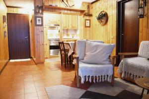 a living room with a chair and a kitchen at Una chicca in Val di Sole in Folgarida