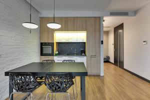 een keuken en eetkamer met een zwarte tafel en stoelen bij Montevideo Centrum 15 by Grand Apartments in Sopot