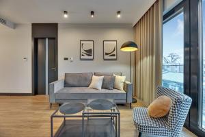 een woonkamer met een bank en twee stoelen bij Montevideo Centrum 15 by Grand Apartments in Sopot