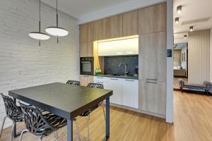een keuken en eetkamer met een tafel en stoelen bij Montevideo Centrum 15 by Grand Apartments in Sopot +10 foto's
