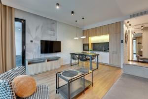 een woonkamer met een tafel en een keuken bij Montevideo Centrum 15 by Grand Apartments in Sopot