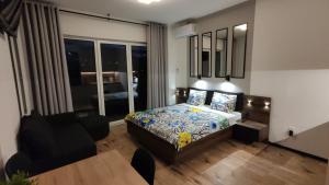 a bedroom with a bed and a living room with a table at One-room apartment Nyska Residence Free garage!!! in Wrocław