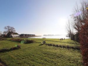 a grassy field next to a body of water at Apartment in Heeg with Heegermeer Views in Heeg