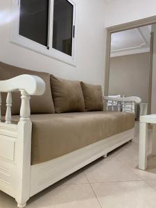 a couch sitting in a living room with a table at Studio Moderne avec terrasse in Er Rachidia +13 photos