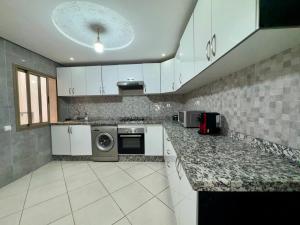 a kitchen with white cabinets and a washer and dryer at Luxury Appartement Centre-ville Kenitra Netflix & IPTV in Kenitra