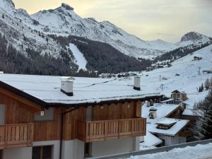 a snow covered roof of a building with mountains in the background at Ciasa Enrico in Arabba