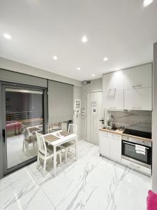 a kitchen with a table and chairs in a kitchen at BlueLine apartment 2 in Loutraki +27 photos