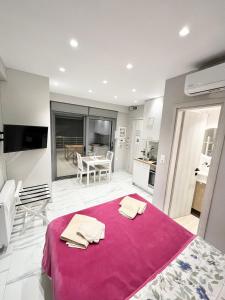 a bedroom with a large bed with a pink blanket at BlueLine apartment 2 in Loutraki