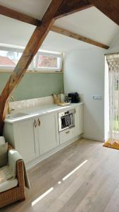 a kitchen with white cabinets and a window in a room at Bovenste appartement in Middelburg +4 photos