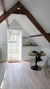 a dining room with a table and chairs and a window at Bovenste appartement in Middelburg