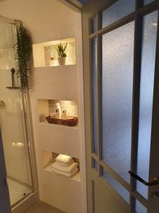 a bathroom with a shower and a glass door with towels at Bovenste appartement in Middelburg