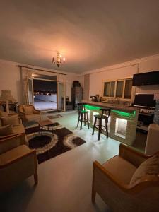 a living room with a table and chairs and a kitchen at The Grand Penthouse in Cairo
