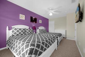 a bedroom with a black and white bed with a purple wall at Lazy River Resort Townhome in Davenport
