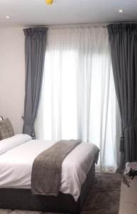 a bedroom with a bed and a large window at Loxwoodhouse Accra Studio Apartment in Accra