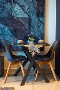 a dining room table with chairs and a painting at Loxwoodhouse Accra Studio Apartment in Accra