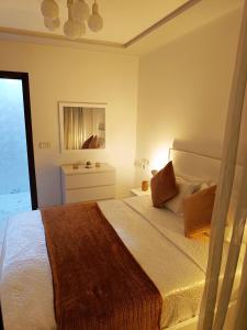 a bedroom with a large bed and a mirror at La Jolie Al Jadid in Nador
