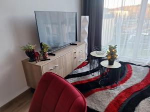 a living room with a large television and two tables at Home sweet home, cozy apartments, free underground parking, long stays welcome in Vilnius