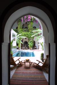 un arco que conduce a un patio con piscina en Riad Dar El Assafir, en Marrakech
