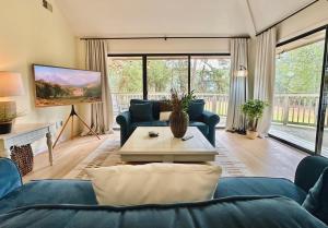 un salon avec des canapés bleus et une table dans l'établissement Golf/ Beach Penthouse Condo, à Sunset Beach