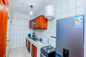 a small kitchen with a stove and a refrigerator at Résidence Le Prestige in Yaoundé