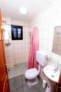 a bathroom with a white toilet and a sink at Résidence Le Prestige in Yaoundé