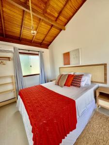 a bedroom with a large bed with a red blanket at Casa João de Barro in Itacaré +39 photos
