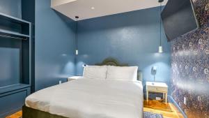 Un dormitorio con una cama con una pared azul. en Bonsoir, en Nueva Orleans