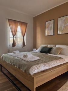 a bedroom with a large bed with two towels on it at Seoski turizam Jagodić in Gorjani