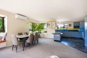 eine Küche und ein Esszimmer mit Tisch und Stühlen in der Unterkunft Mountain Majesty on Orchard-Wanaka Holiday Home in Wanaka