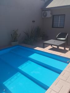 een blauw zwembad met een tafel en een stoel bij Brisas Iguazú II in Puerto Iguazú +40 foto's