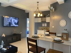 a kitchen and living room with a table and chairs at Dajon Apartments - Generator & Starlink in General Luna